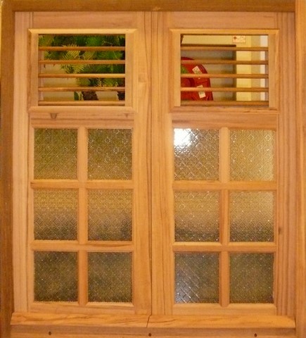 Fenêtre à petit carreaux et imposte lames de bois.